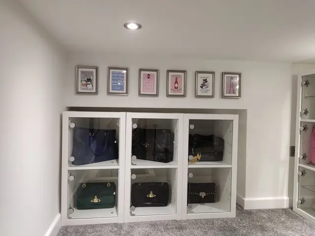 IKEA glass-door storage units with a row of frames hung above
